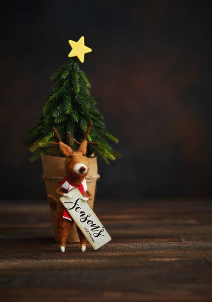 istock Cute Christmas Background with Tree and Felt Reindeer Holding Holiday Greeting 1271445920