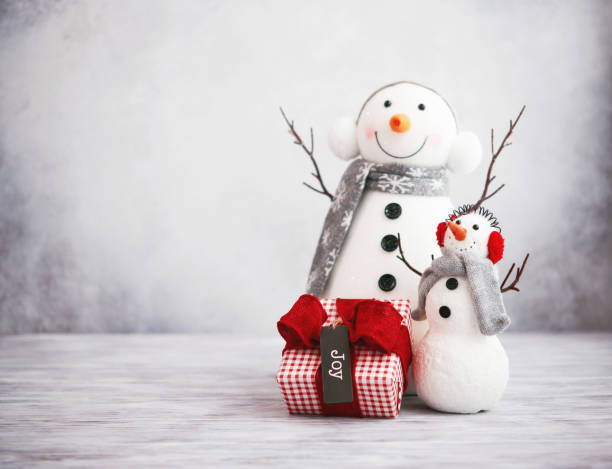 istock Cute Christmas background with snowmen and gift in bright setting 1271450233