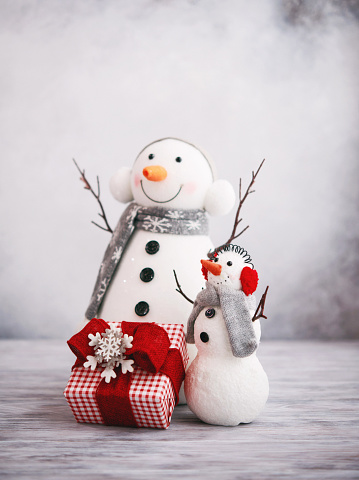 Cute Christmas background with snowmen and gift in bright setting