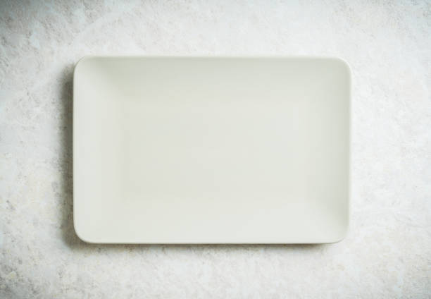 istock Clean light gray square plate on the white background. Shot from above. 1271453254