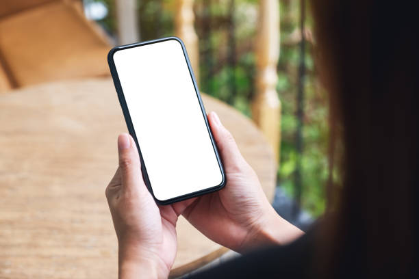 istock a woman holding mobile phone with blank white desktop screen 1271453543