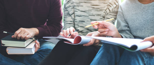 istock Group of young students tutoring and catching up workbook together 1271453605