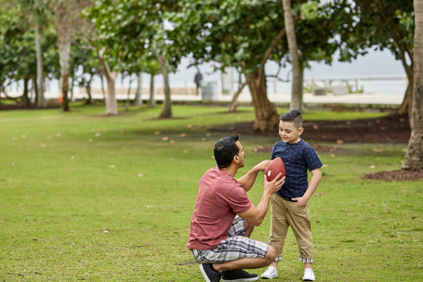 istock Father Coaching Young Son About Football at Public Park 1271464255