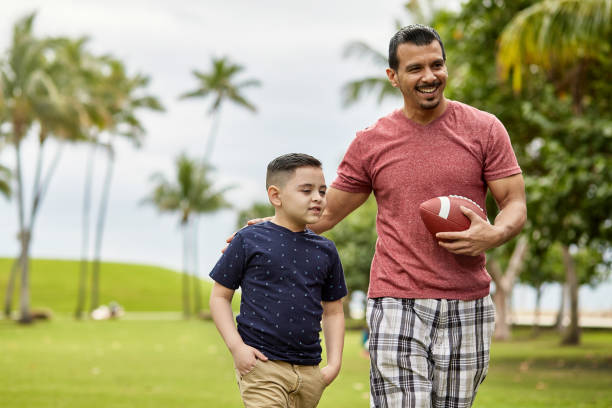 istock Smiling Father and Son Playing Catch at Public Park 1271464786