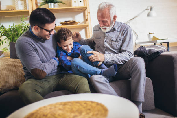 istock Three generations of men having fun together, sitting on couch. 1271464903
