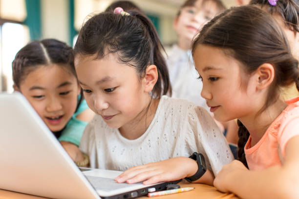 istock Happy children using the laptop  in the classroom 1271467402