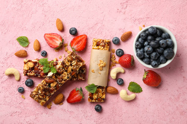 istock Granola bars and bowl with blueberry on pink background, top view 1271468562