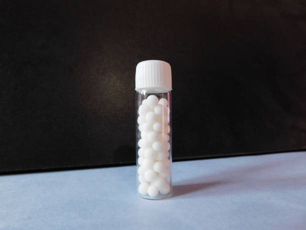 una bottiglia di medicina omeopatica isolata su una superficie - omeopatia foto e immagini stock