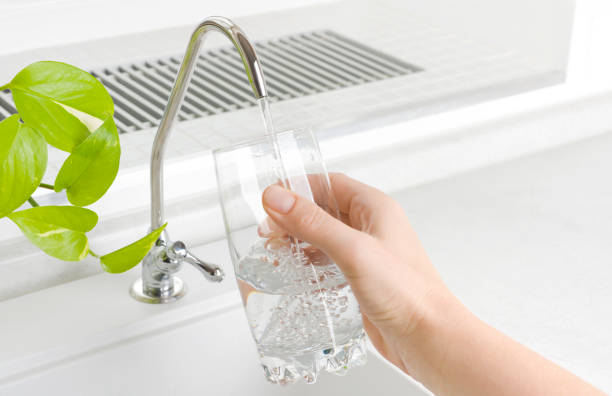 キッチンフィルタータップから水のガラスを注ぐ手 - faucet glass water running water ストックフォトと画像