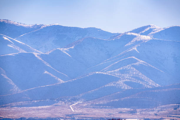 Utah valley mountain landscape in winter with rugged terrain covered with snow. Zoomed photo with blueish haze in the morning