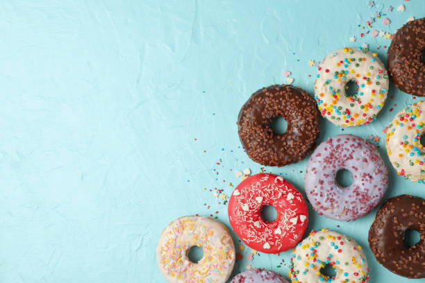 istock Tasty donuts on blue background, top view 1271472655