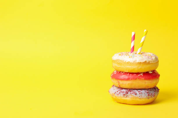 istock Tasty donuts with straws on yellow background, space for text 1271472733