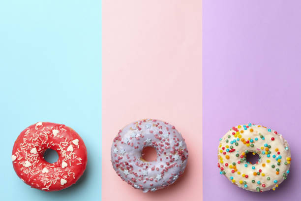 istock Tasty donuts on three tone background, top view 1271472980