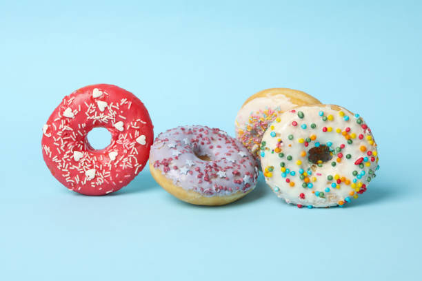 istock Four different tasty donuts on blue background 1271473001