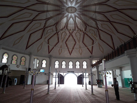 Penang, Malaysia, November 30, 2017: A man prays under the dome inside the Tanjung Bungah Floating Mosque. Penang. Malaysia