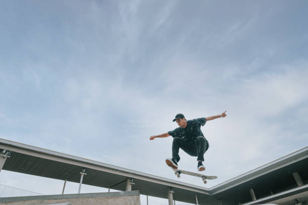 istock Asian skateboarder in action mid air 1271473389