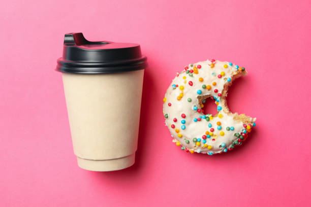istock Paper cup and donut on pink background 1271473523