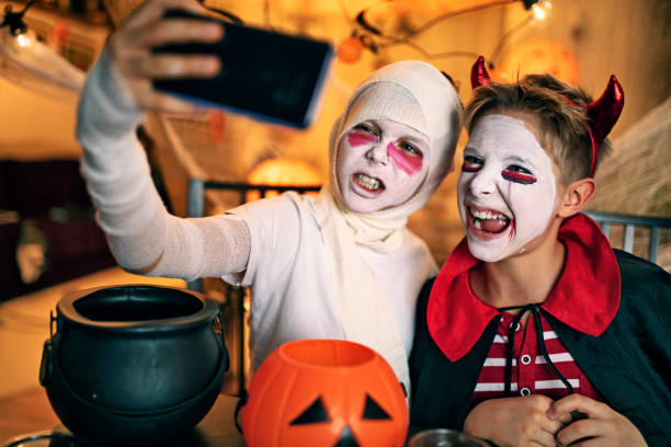 Two boys taking selfies at Halloween party Two little boys taking selfies and making scary faces to the camera. Boys are dressed us as devil and mummy.
Nikon D850 halloween face paint stock pictures, royalty-free photos & images