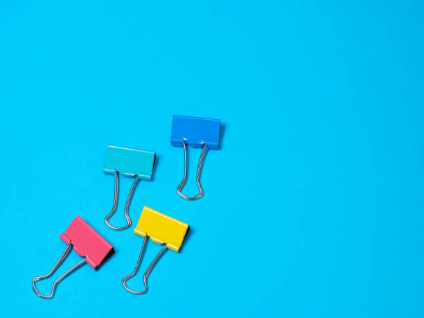 istock Multicolored different metal binder clip on blue background 1271474386