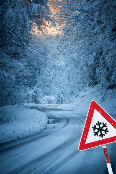 istock Snowy road with warning sign 1271475818