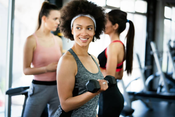 istock Beautiful fit people exercising together in gym 1271478236