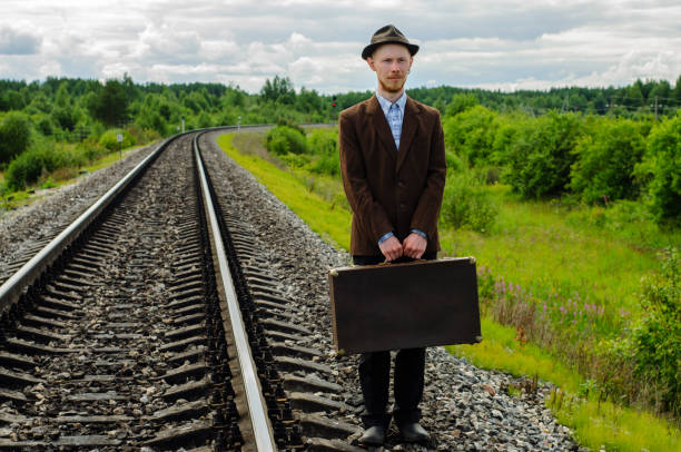 istock Man hipster with old retro suitcase on railway 1271484245