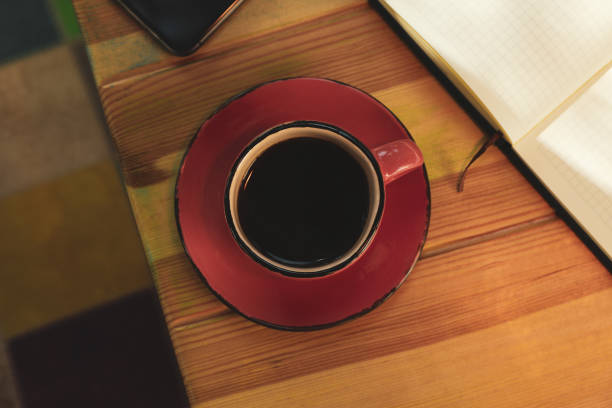 istock Cup of coffee, notebook and phone on wooden table 1271487501
