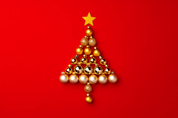 istock Christmas tree made of gold baubles on red background 1271487963