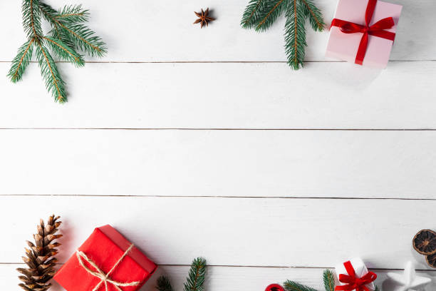 istock Beautiful Christmas composition on wooden white background with Christmas gift boxes, snowy fir branches, conifer cones, cinnamon dried fruits, holiday decoration, caramel stick. New Year. Top view, copy space. 1271489521