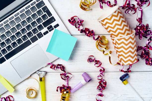 istock Office desk with laptop and open notepad  decorated with party streamers 1271489639