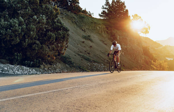istock Professional cyclist on a mountain road at sunrise 1271491026