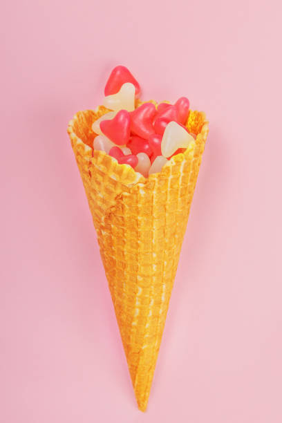 istock waffle cone with gummy hearts on a pink background. vertical frame 1271491082