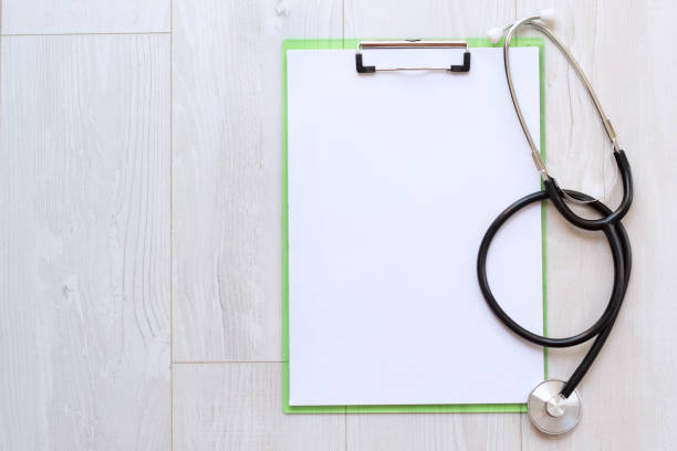 istock Blank medical clipboard with stethoscope on wood background. Copy space. 1271491159