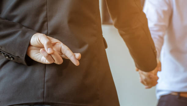 Betrayal partners pretend to shake hands to make a deal, It is a picture of the working atmosphere of company employees in the office in the early 21st century. stock photo