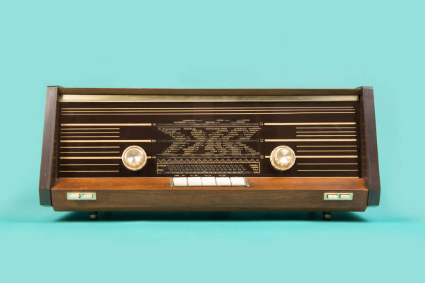 ターコイズブルーの背景に正面から見たアンティークレトロラジオ - radio old fashioned antique yellow ストックフォトと画像