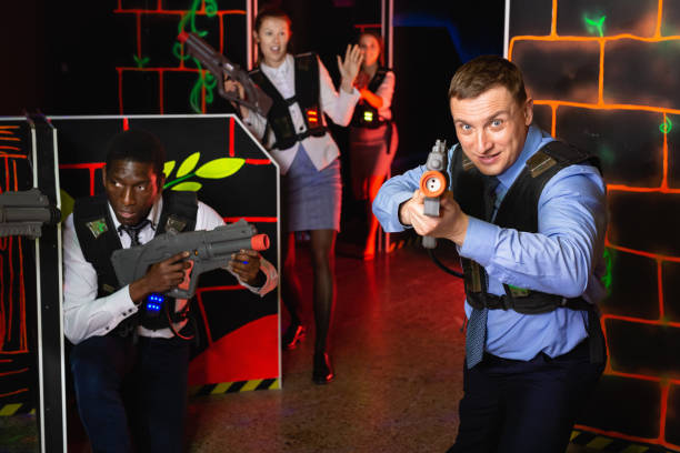 istock Group of colleagues holding laser pistols playing laser tag game 1271492214