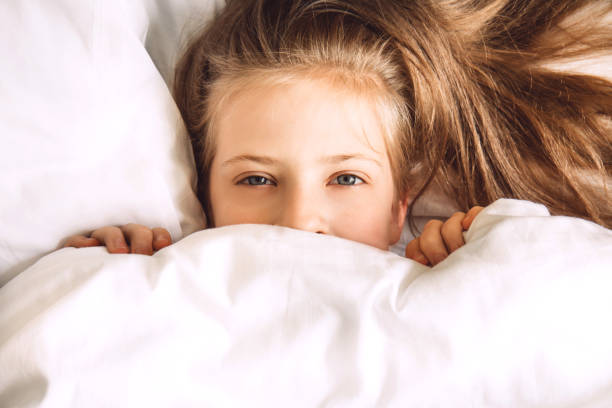 istock Child hiding under duvet in bed 1271492568
