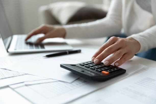 istock Close up woman using calculator and computer app, managing budget. 1271492861
