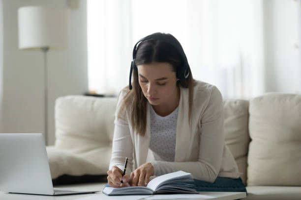 istock Young lady in wireless headset listening to online educational lecture. 1271492889