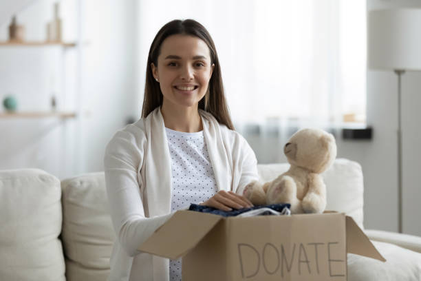 istock Happy young woman holding cardboard donation box on laps. 1271492957