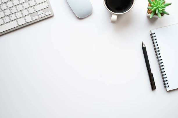 istock Top view above of White office desk table with keyboard, notebook and coffee cup with equipment other office supplies. Business and finance concept. Workplace, Flat lay with blank copy space. 1271494499