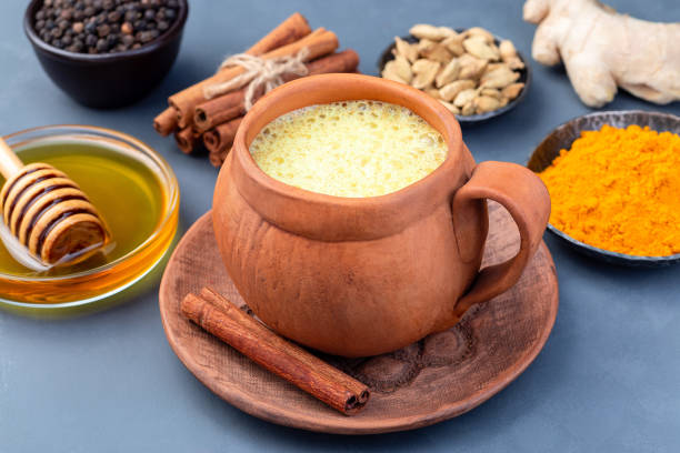 istock Yellow moon milk with turmeric in clay cup, ingredients on background, horizontal 1271495185