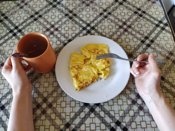 Woman eats omelette first person photo