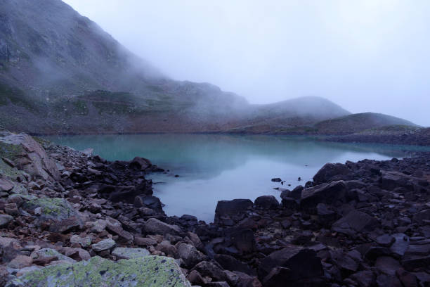 istock Alpine lake in the clouds. 1271500303