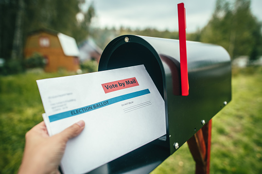 Hispanic Couple Checking Mailbox Holding Mail and Smiling at Camera