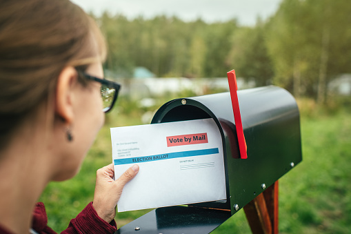 woman looking at letter in mailbox