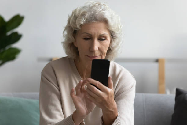 istock Serious mature middle aged woman using smartphone, looking at screen 1271502049