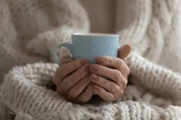 Photo of Close up mature woman wrapped warm blanket holding mug