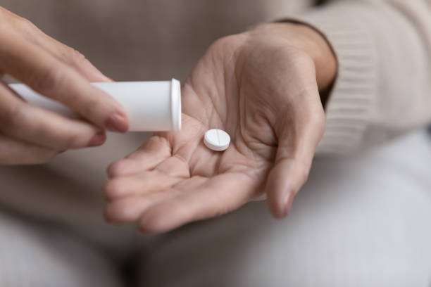 istock Close up mature woman taking out pill from plastic bottle 1271502111