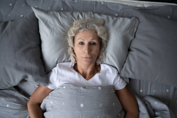 istock Top view sleepless mature woman lying in bed, insomnia concept 1271502156